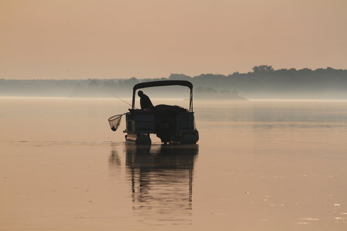 Man on a pontoon boat fishing on the Saint Lawrence River
